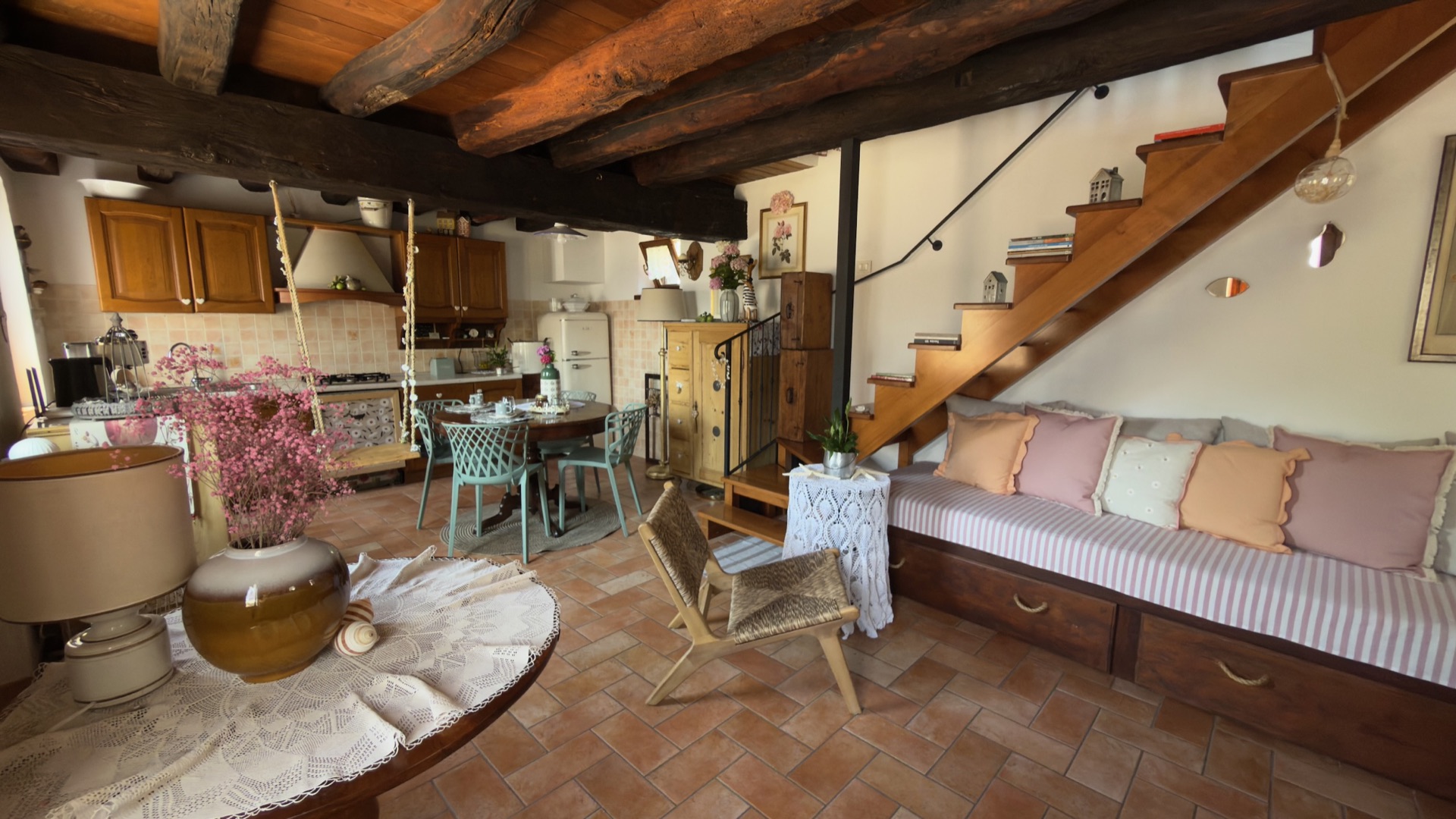 Cucina, zona pranzo e scala in legno al piano terra