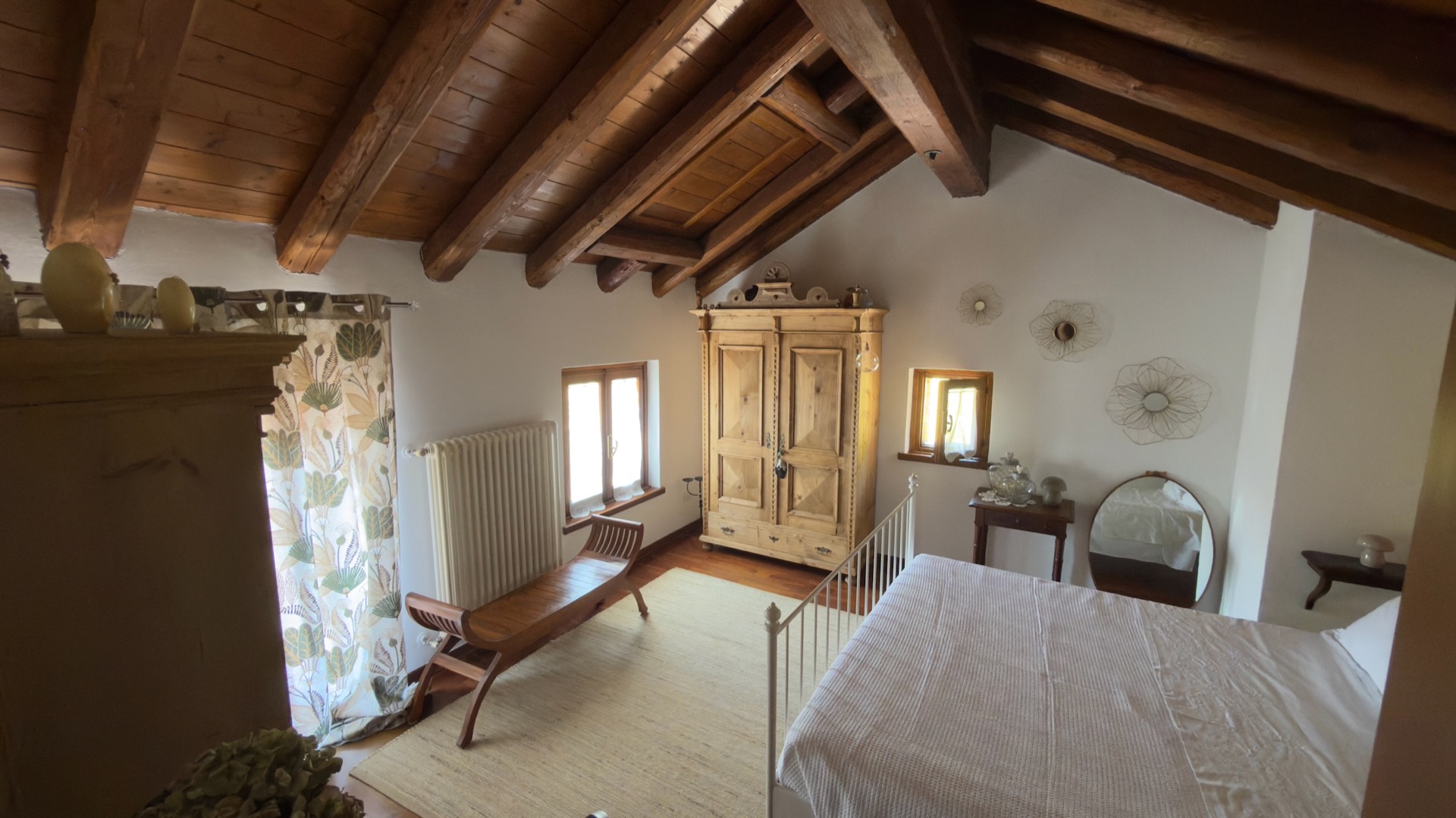 Camera matrimoniale sotto il tetto in legno con travi a vista