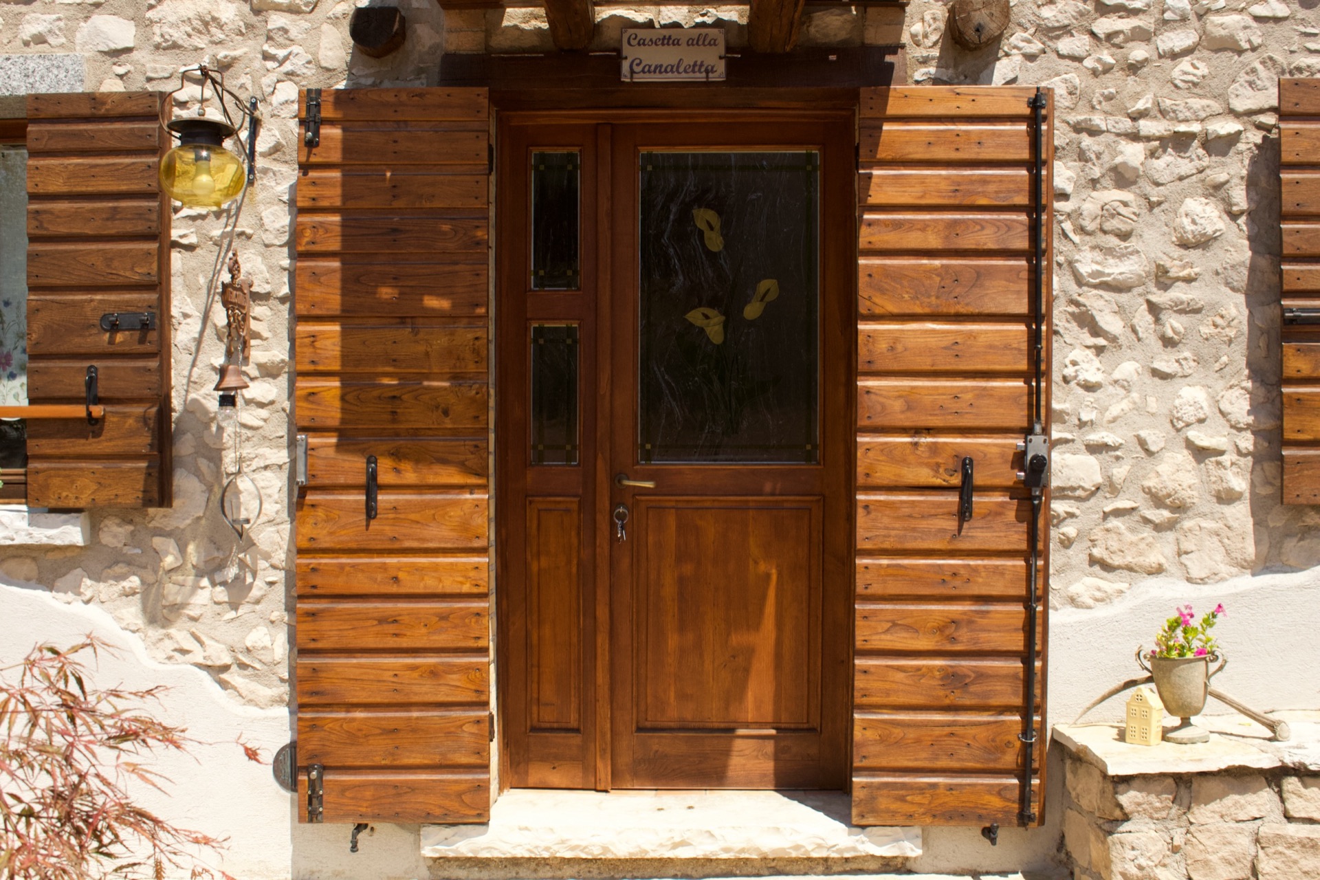 La corte con tavolo, ombrellone e la roggia di pietra